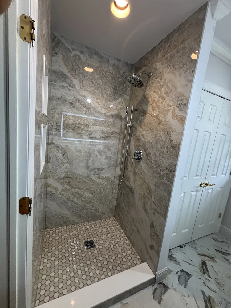 Walk-in shower with stone-look wall tile, two niches and a hexagon mosaic floor