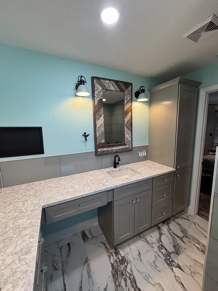 Master bath vanity with grey cabinets, a reclaimed-wood mirror frame and marble-look floor
