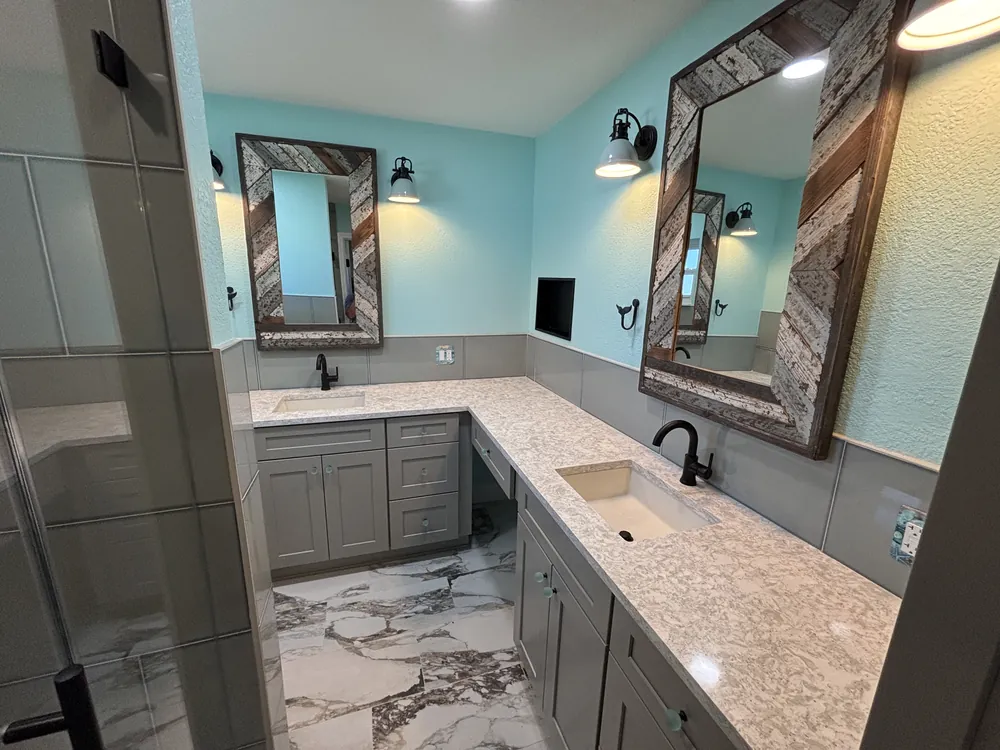 Master bathroom with a grey double vanity, two framed mirrors and marble-look porcelain floor