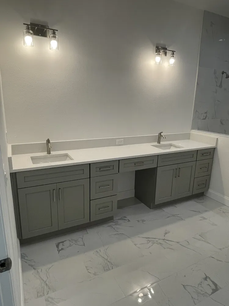 Grey double vanity with a makeup station and marble-look porcelain floor