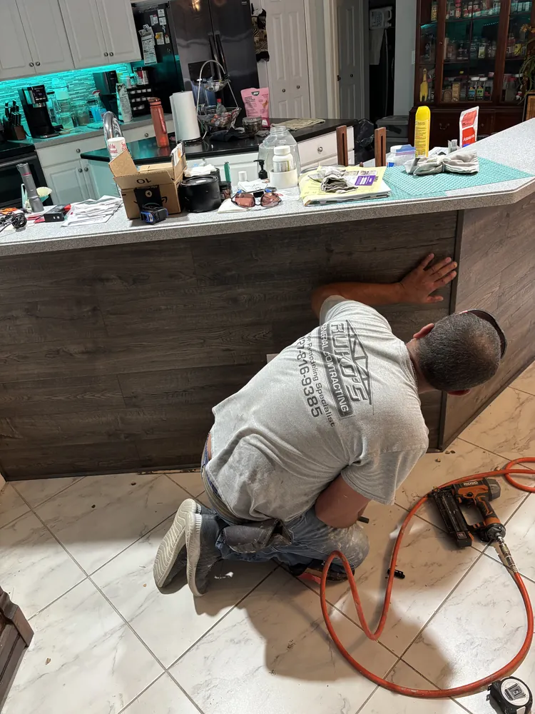 Ruko's crew member installing wood plank panels on a home bar