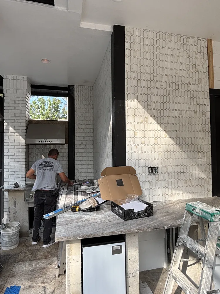 Ruko's crew installing a tile backsplash around a kitchen range hood