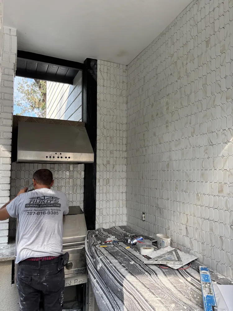 Ruko's installer setting backsplash tile in a kitchen remodel