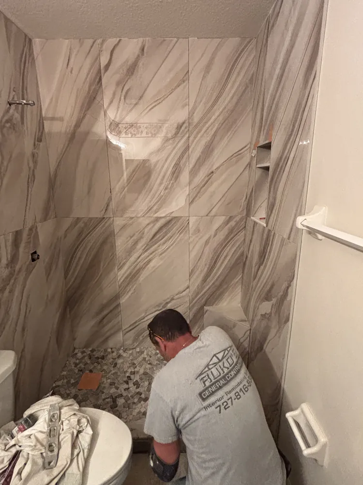 Ruko's installer laying a pebble mosaic shower floor