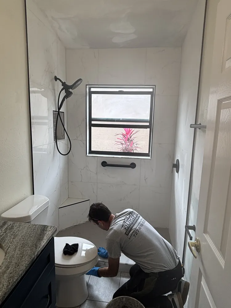 Ruko's crew member finishing floor tile in a bathroom remodel