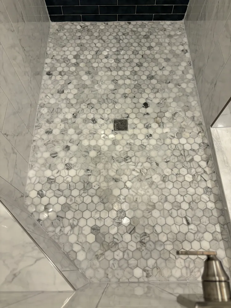 Grey marble hexagon mosaic tile installed as a shower floor