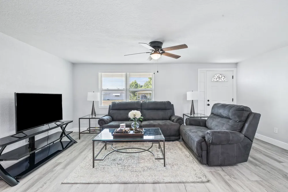 Living room with new wood-look plank flooring, fresh paint and recessed lighting