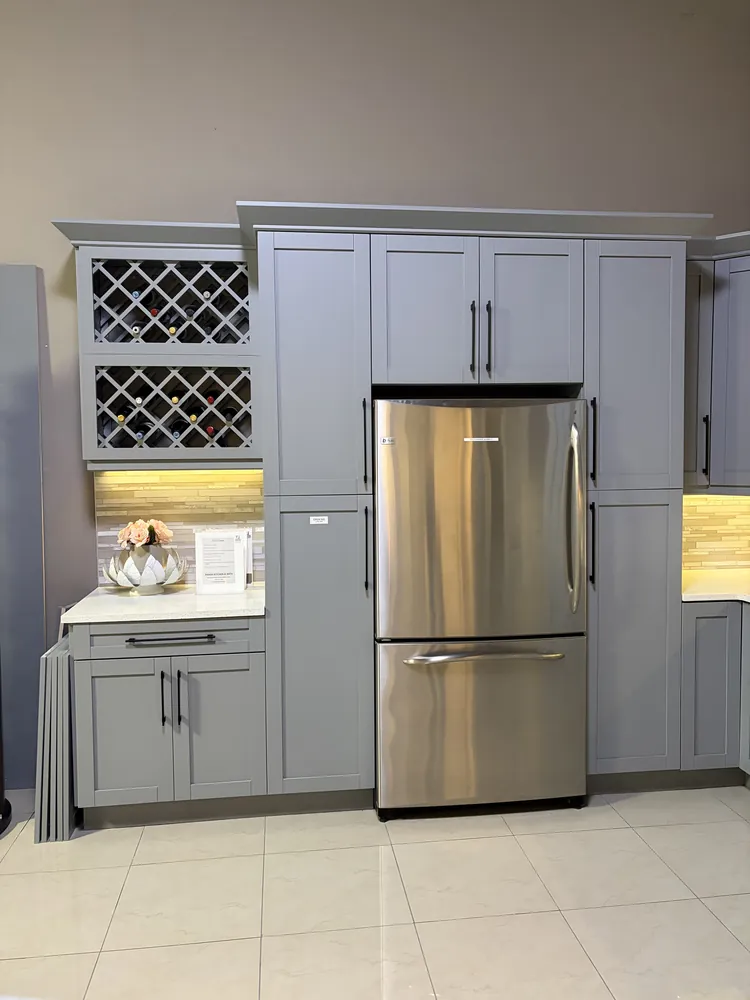 Kitchen pantry wall with grey shaker cabinets, a built-in wine rack and stainless refrigerator