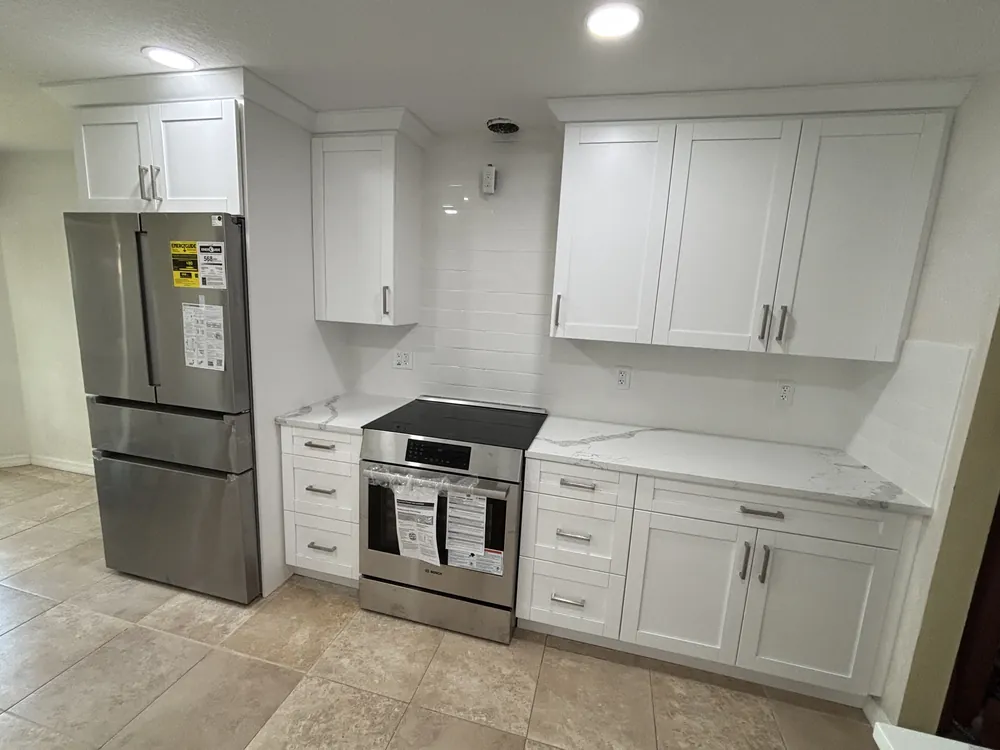 White shaker kitchen with a slide-in range, subway tile backsplash and quartz counters